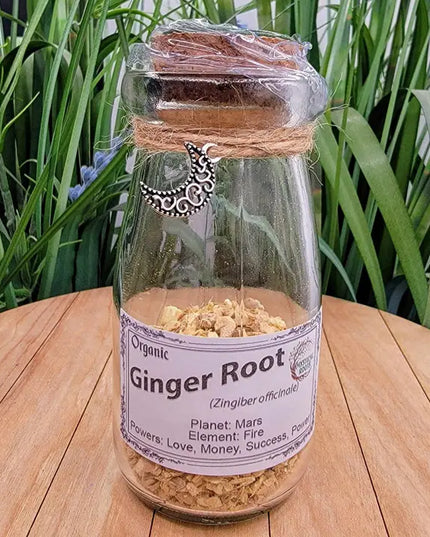 Glass bottle labeled 'Organic Ginger Root' on a wooden surface with plants in the background