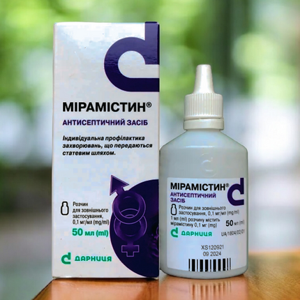 Mipamistin bottle and box on a wooden surface with a blurred green background