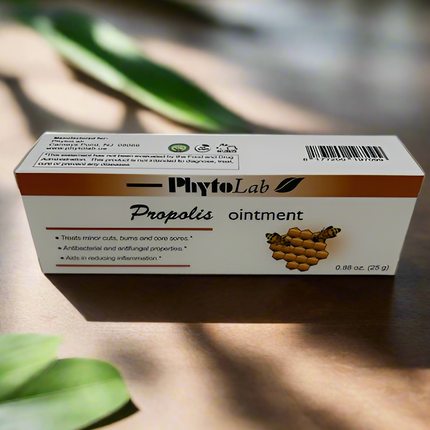 Box of PhytoLab Propolis ointment on a wooden surface with green leaves in the background