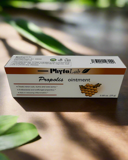 Box of PhytoLab Propolis ointment on a wooden surface with green leaves in the background