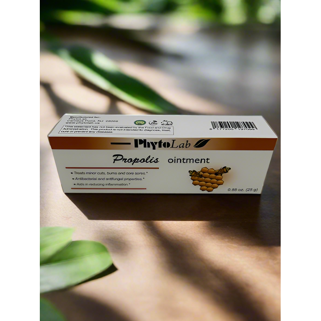 Box of PhytoLab Propolis ointment on a wooden surface with green leaves in the background