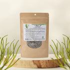 Sealed package of dried herbs on a wooden surface with a white background