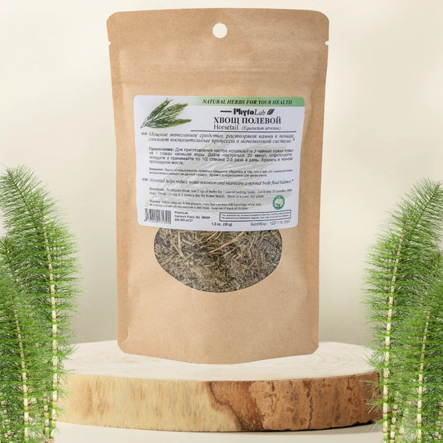 Kraft paper packaging with a label featuring dried herbs on a wooden surface with decorative plants.